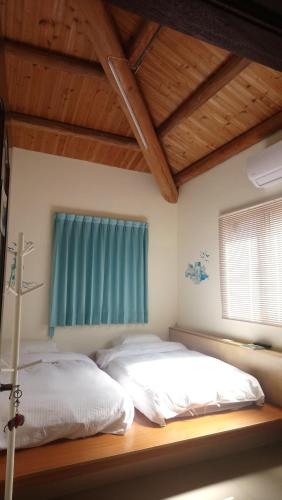 1 dormitorio con 2 camas y ventana en Jinsha Sea Cloud B&B, en Nangan