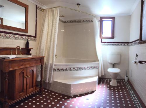a bathroom with a tub and a sink and a toilet at Greenock's Old Telegraph Station in Greenock