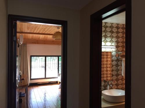 Habitación con baño con espejo y lavabo. en Yunhe Titian Fengyin Inn en Yunhe