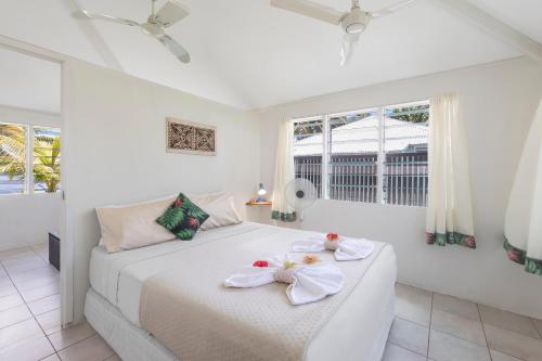 a white bedroom with a bed with towels on it at Savaii Lagoon Resort in Fagamalo