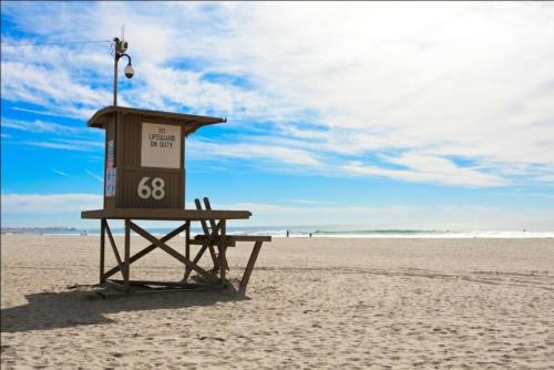 a lifeguard stand on a beach with a blue sky at Newport Beach House 1 blk to beach and 25 min to Disney in Newport Beach