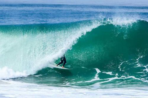 a person riding a wave on a surfboard in the ocean at Newport Beach House 1 blk to beach and 25 min to Disney in Newport Beach