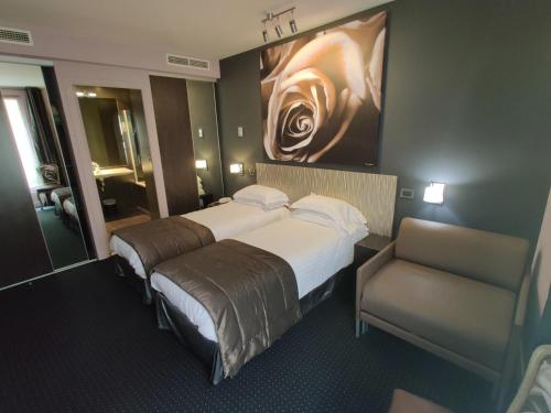 a hotel room with two beds and a chair at Hôtel Le Fabe in Paris