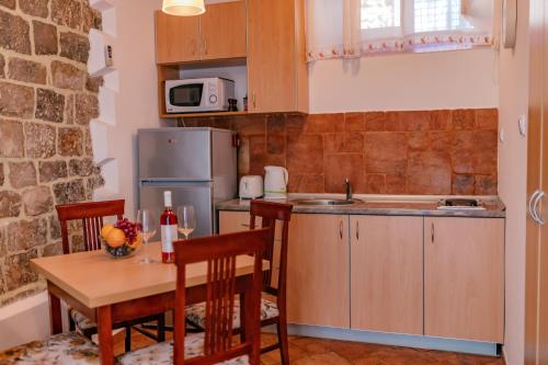 a kitchen with a wooden table and a kitchen with a table and chairs at Apartments Bigovo Veljic in Tivat