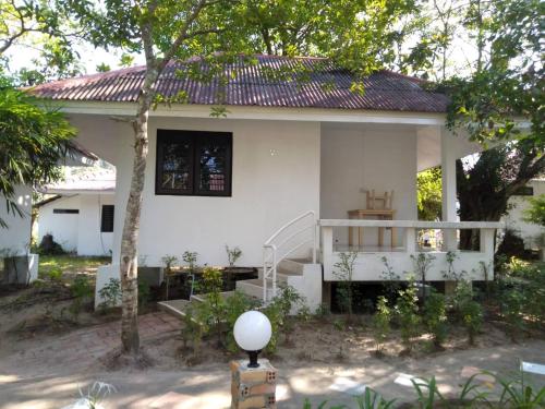 a white house with a staircase in front of it at LayTrang Pakmeng Marina Spa and Resort in Trang