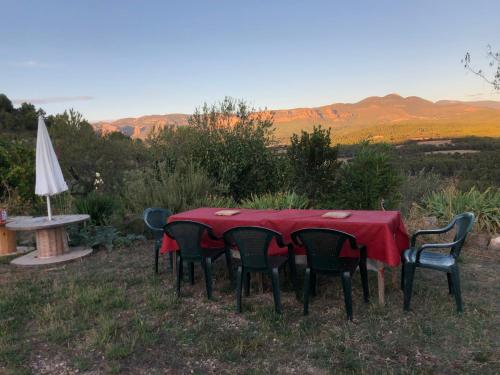 a table and chairs with a table and an umbrella at Solano de Moran in Murillo de Gállego