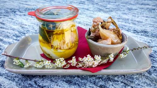a jar of honey on a plate with a bowl of flowers at Agriturismo Treterre in Pianello Del Lario
