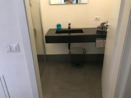 baño con lavabo negro y espejo en casa dei nonni 2, en Tremosine Sul Garda