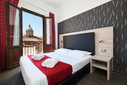 a bedroom with a large bed with towels on it at La Terrazza sul Centro in Palermo