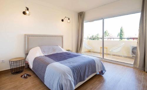 a bedroom with a bed and a large window at Apartment Club Playa Flores Torremolinos in Torremolinos