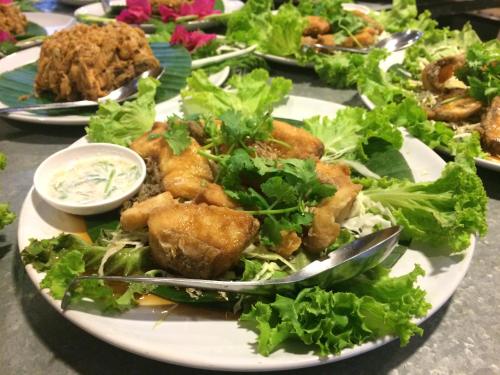 a plate of food with a salad on a table at LayTrang Pakmeng Marina Spa and Resort in Trang