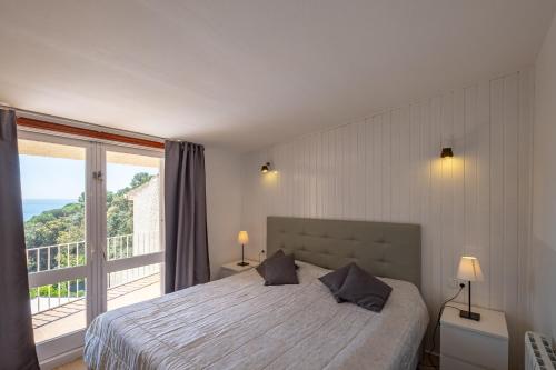 a bedroom with a bed and a large window at Villa Montemar in Tossa de Mar