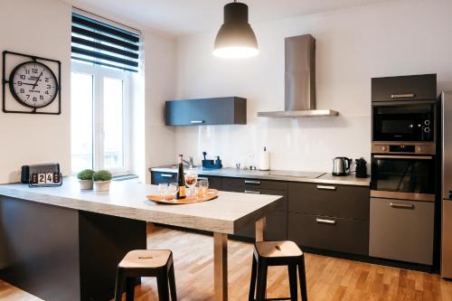 a kitchen with a table and a clock on the wall at LE 17 in Colmar