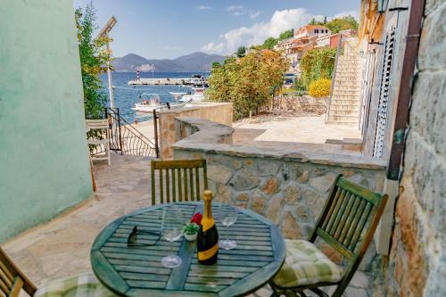 a table with a bottle of wine sitting on a balcony at Apartments Bigovo Veljic in Tivat