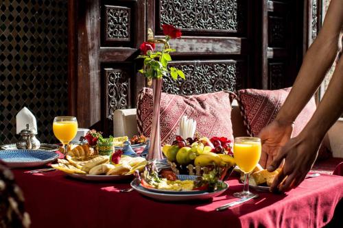 a table with food and drinks on a red table cloth at Riad Mabrouk in Marrakech