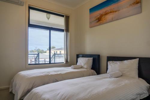 2 camas en una habitación con ventana en Tasha's Apartments on Kerry, en Pennington