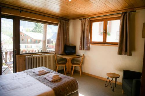 a bedroom with a bed and a desk with a computer at Le Dahu in Chamonix-Mont-Blanc
