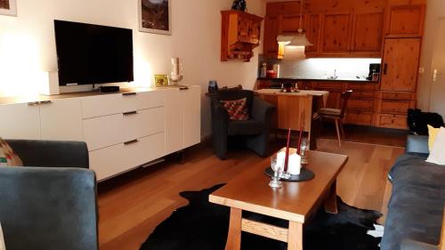 a living room with a tv and a couch and a table at I dr Rehwiesa A13 in Arosa