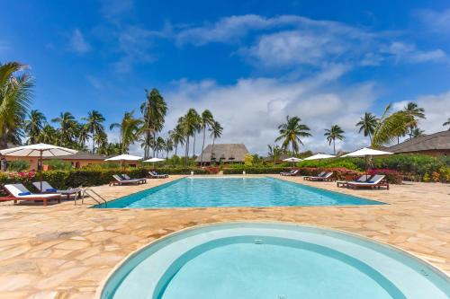 a pool at the resort with chairs and umbrellas at The Sands Beach Resort in Bwejuu