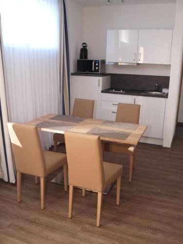 a dining room table with chairs and a kitchen at Hotel Anker garni in Rastatt