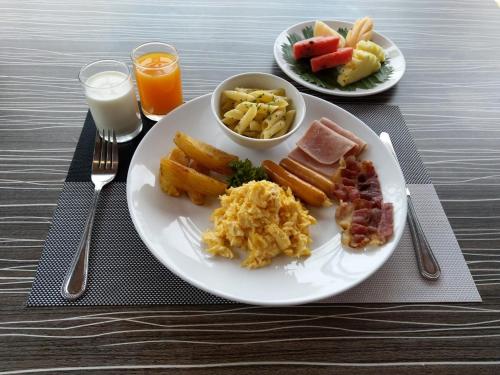 een bord ontbijt op tafel met melk bij Woraburi Phuket Resort & Spa - SHA Plus in Karon Beach