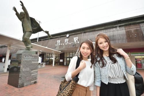 two young women standing in front of a statue at Hotel Seawave Beppu in Beppu