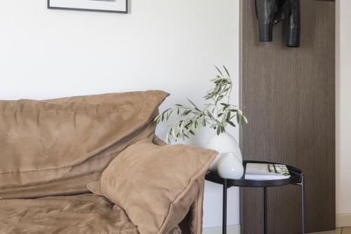 a couch with a pillow and a plant on a side table at Residence La Vigna in Arco