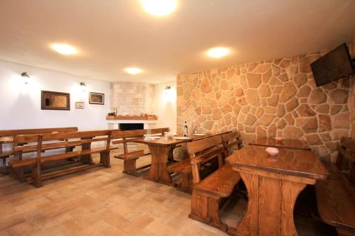 a room with wooden benches and a stone wall at Robinson Marko in Gdinj