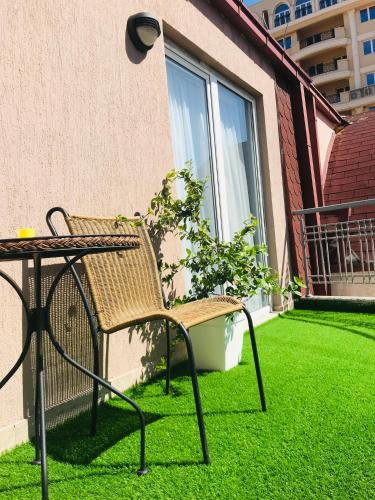 a wicker chair sitting next to a table on a lawn at VNVP Apartment in Štip