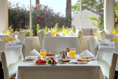 a table with plates of food and orange juice at Ein Gev Holiday Resort in En Gev