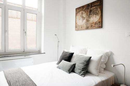 1 dormitorio blanco con 1 cama con 2 almohadas en LE 17 en Colmar