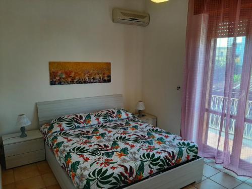 een slaapkamer met een bed en een schilderij aan de muur bij Casa Monti in Scauri