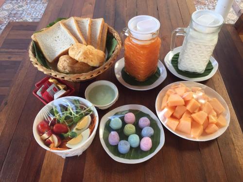 a wooden table topped with plates of food and drinks at Baan Suan Krung Kao in Phra Nakhon Si Ayutthaya