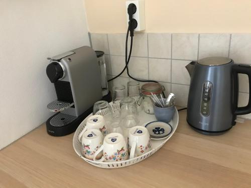 a counter with a tray of cups and a coffee maker at B&B Loon in Loon