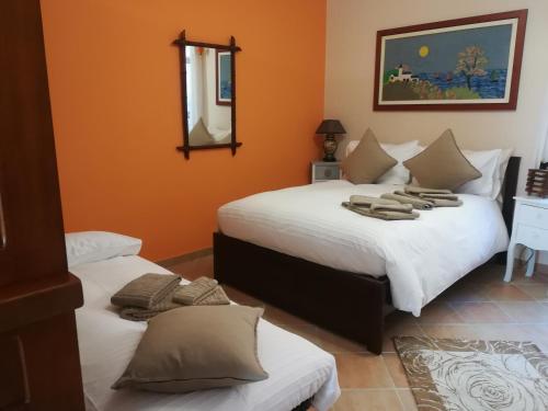 a bedroom with two beds and a mirror on the wall at Casarina in Ventimiglia