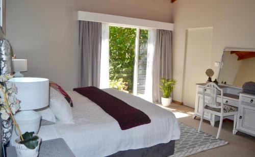 a bedroom with a bed and a desk and a window at Retreat in Hillcrest