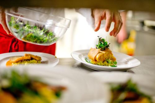 a person preparing food on a counter with plates of food at Hotel NockResort in Bad Kleinkirchheim