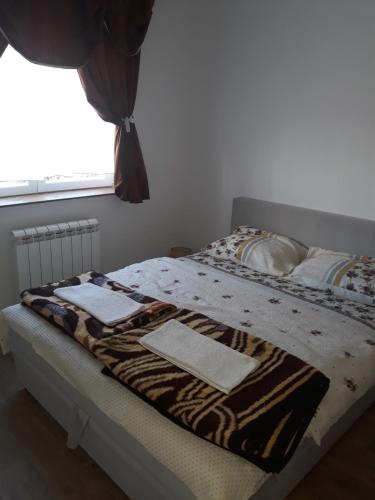 a bed with a zebra print blanket on it at Iznad Oblaka A5 in Kopaonik