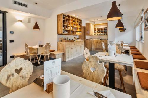 a restaurant with wooden chairs and tables in a room at Camina Suite and Spa in Cortina dʼAmpezzo
