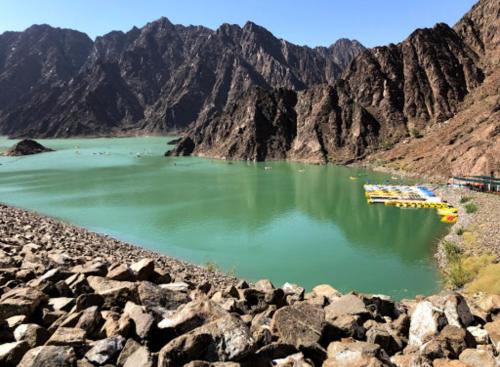 a body of water with mountains in the background at Happiness Farm in Hatta