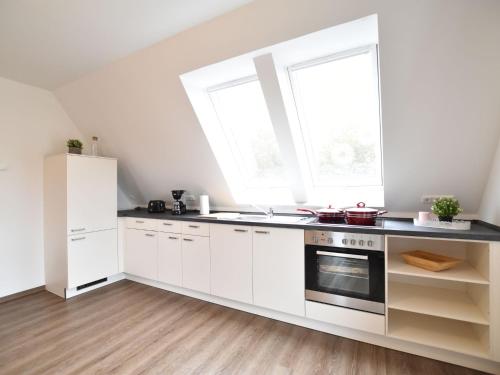 a kitchen with white cabinets and a window at Coastal Comfort on Poel Island in Insel Poel
