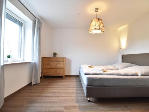 a bedroom with a bed and a dresser and a window at Coastal Comfort on Poel Island in Insel Poel