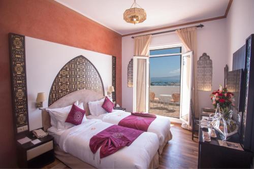 a bedroom with a bed and a large window at El Minzah Hotel in Tangier