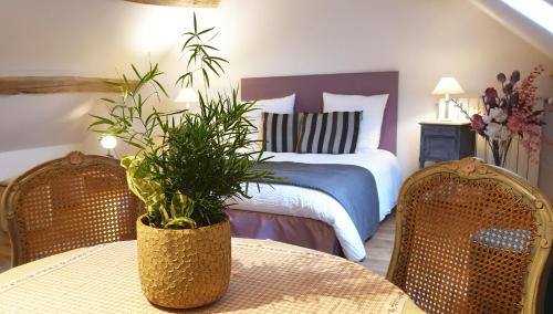 - une chambre avec un lit, une table et des chaises dans l'établissement Le champ de l'eau, à Crécy-la-Chapelle