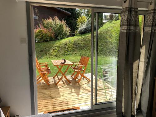 una puerta corredera de cristal con una mesa y sillas en una terraza en Le petit Chamois, en Saint-Gervais-les-Bains