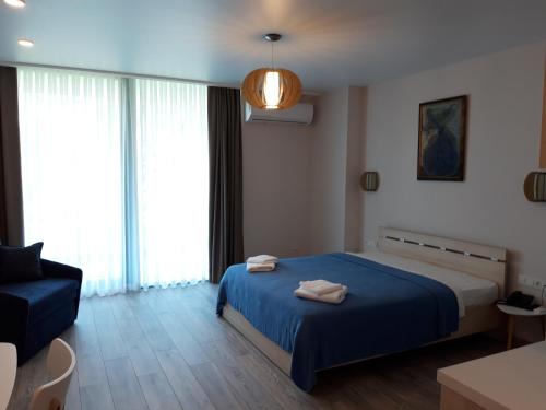 a bedroom with a blue bed and a couch at Green Line in Mtsvane Kontskhi