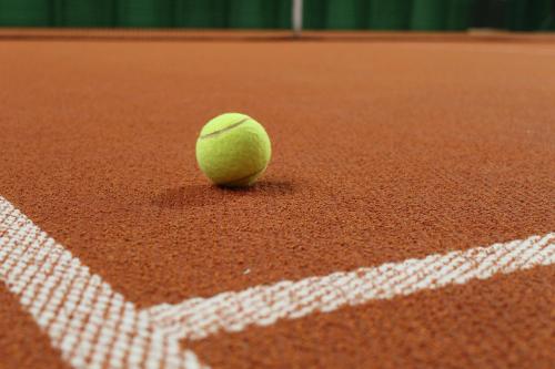 a green tennis ball sitting on a tennis court at Vital & Sporthotel Brixen in Brixen im Thale
