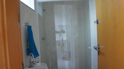 a bathroom with a shower with a sink and a toilet at Imbassai Summer Flats Village in Imbassai