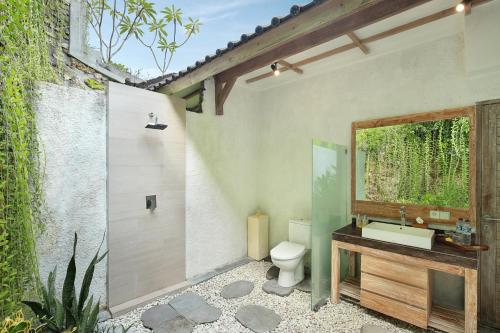 a bathroom with a toilet and a sink at The Acala Shri Sedana in Nusa Lembongan