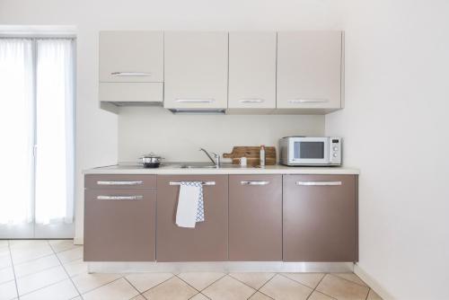 a kitchen with white cabinets and a microwave at Residence La Vigna in Arco
